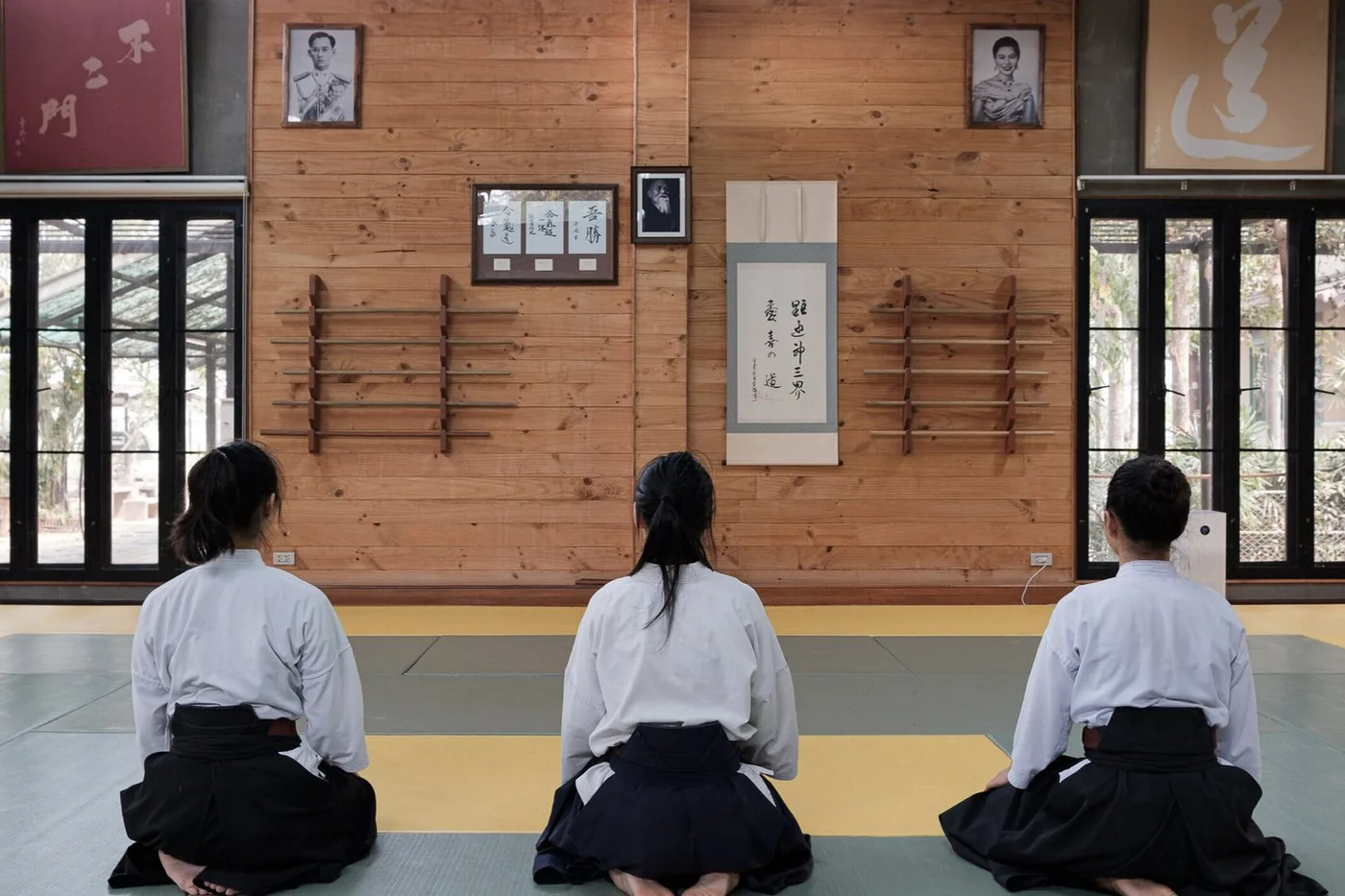 Three aikido students kneeling in seiza before class at Renshinkan Dojo
