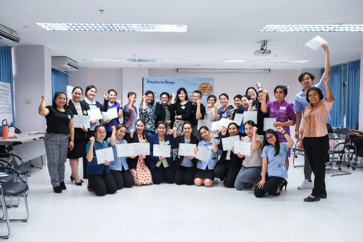 Parents holding certificates after a parenting workshop