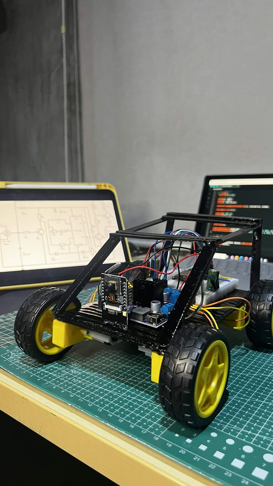 A four-wheel RC-car prototype with an ESP32 board, motor driver, wiring, and open frame.