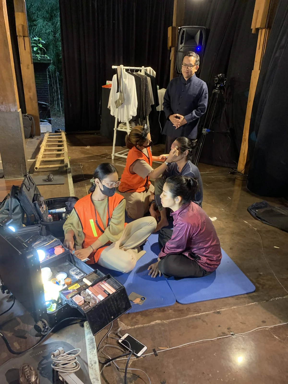 A production team preparing makeup, costumes, and materials backstage for TERASIA.
